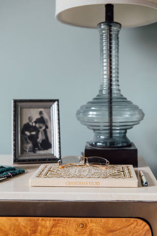 Decorative lamp with a book titled 'Grandma's Story' on a wooden surface.