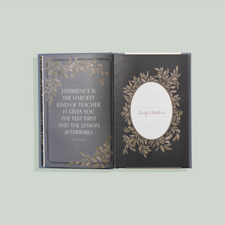 Decorative book with engraved text and design on a light gray background