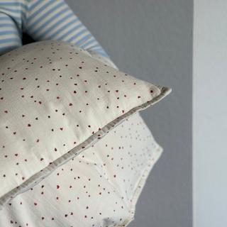 Close-up of a pillow with heart pattern against a gray background